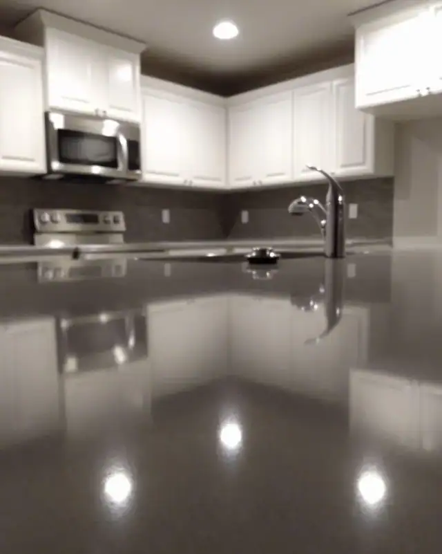 A polished quartz countertop reflecting white kitchen cabinets after a house cleaning in Central Oregon