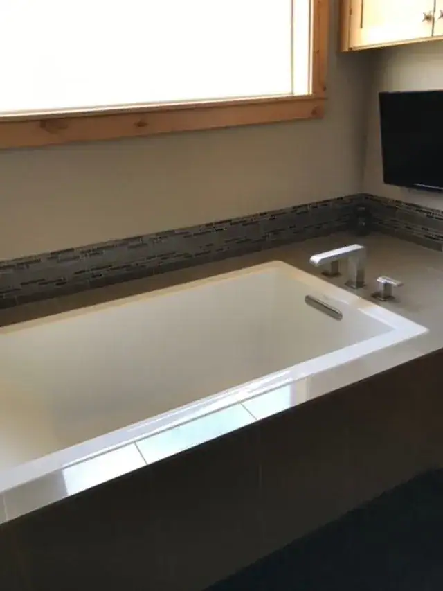 A clean soaking tub under a window